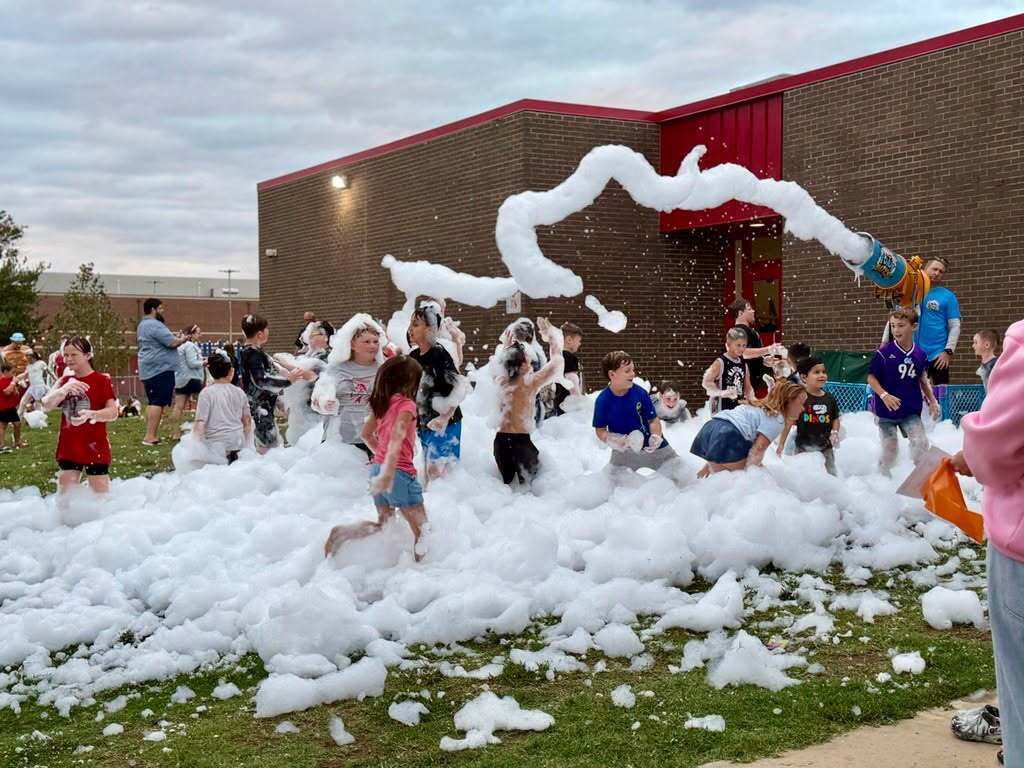 Students run and play through piles of foam at the Fall Festival.