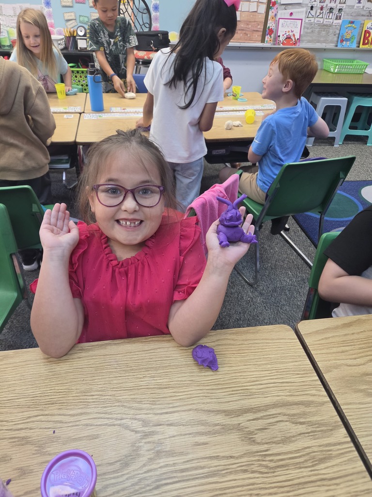student smiling with playdoh