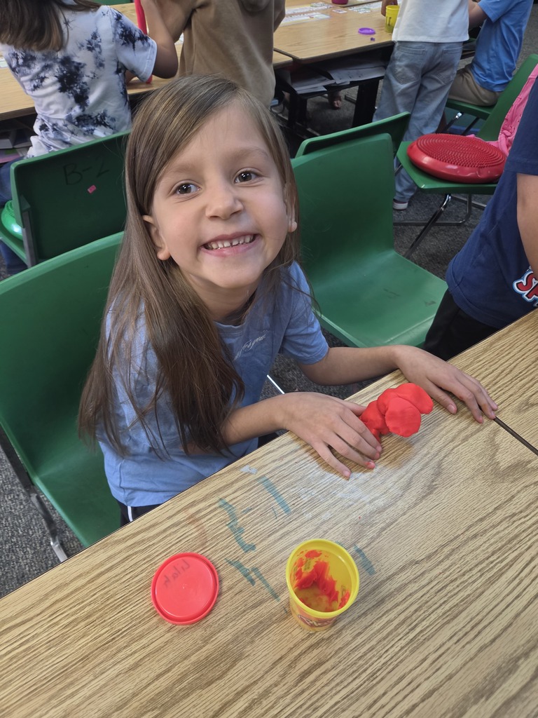 student smiling with playdoh
