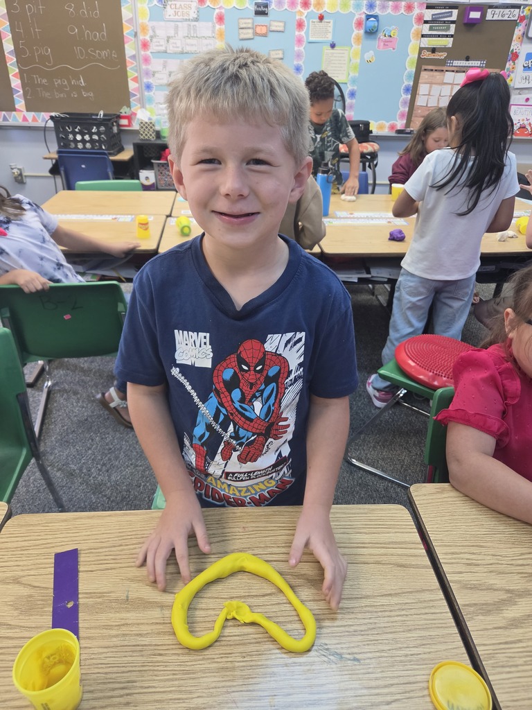 student smiling with playdoh