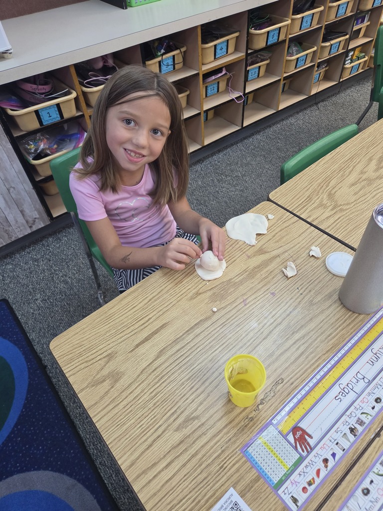 student smiling with playdoh