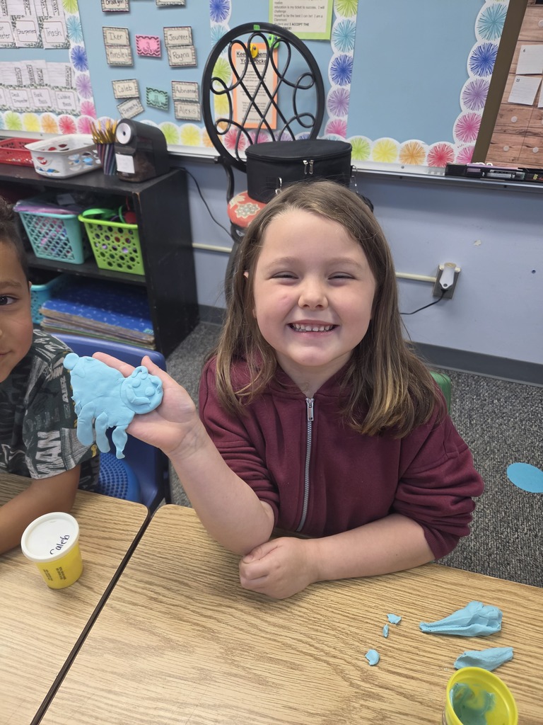 student smiling with playdoh