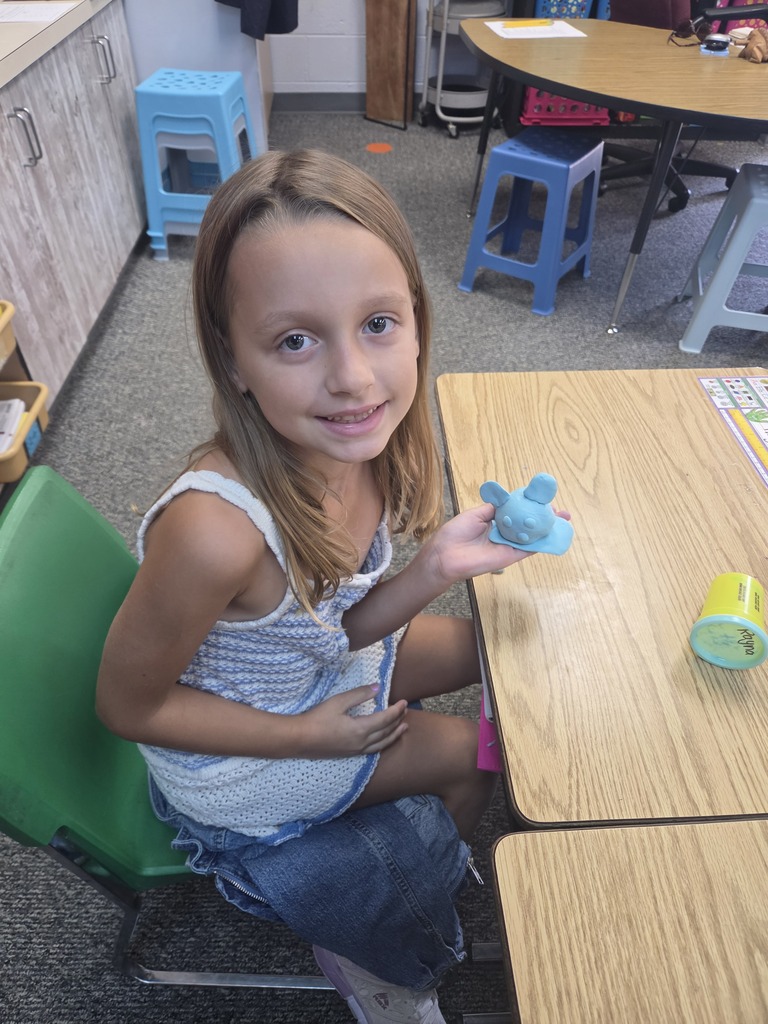 student smiling with playdoh