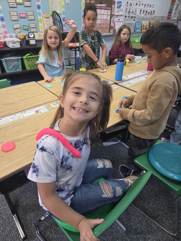 students smiling with playdoh