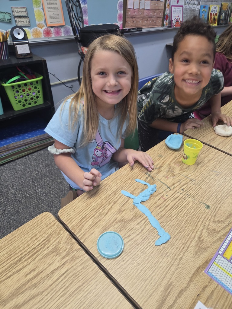 students smiling with playdoh