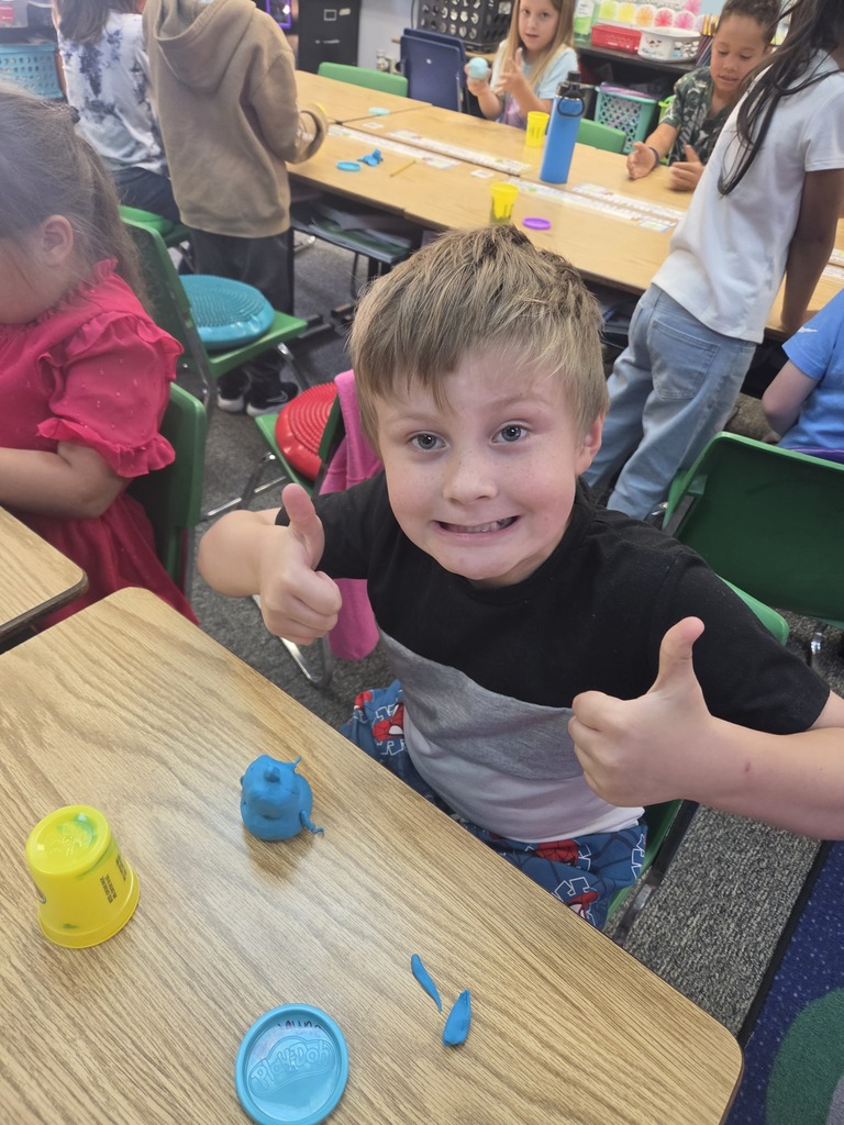 student smiling with playdoh