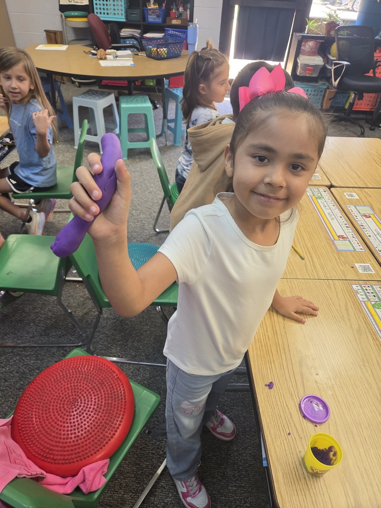 student smiling with playdoh