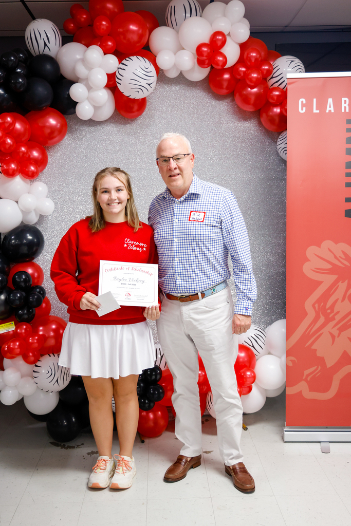 CHS senior holding an Alumni Association scholarship certificate with an alumnus.