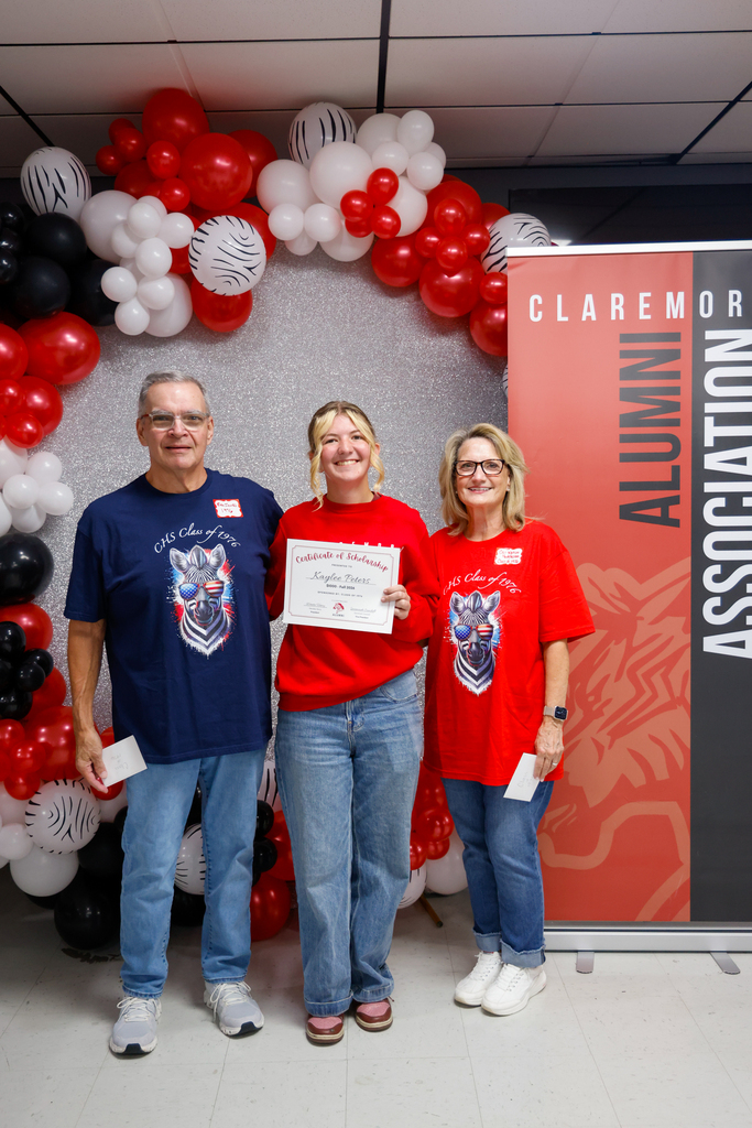 CHS senior holding a scholarship certificate with two members of the Class of 1976.