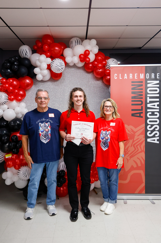 CHS senior holding a scholarship certificate with two members of the Class of 1976.