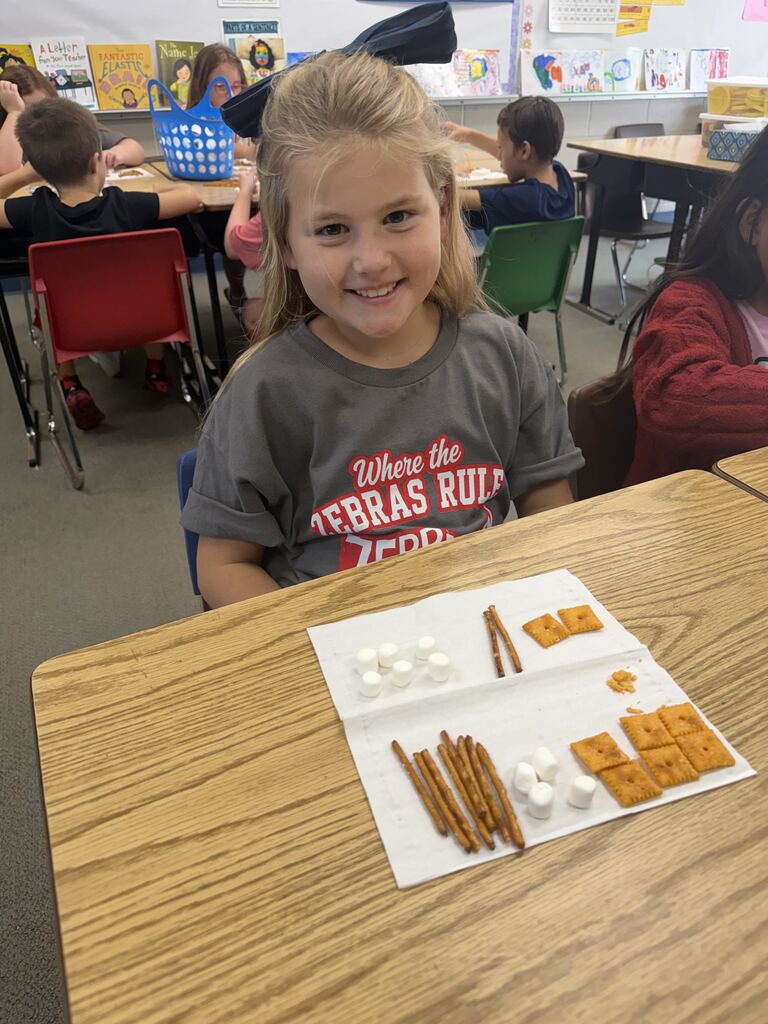 student smiling with snacks in front of her