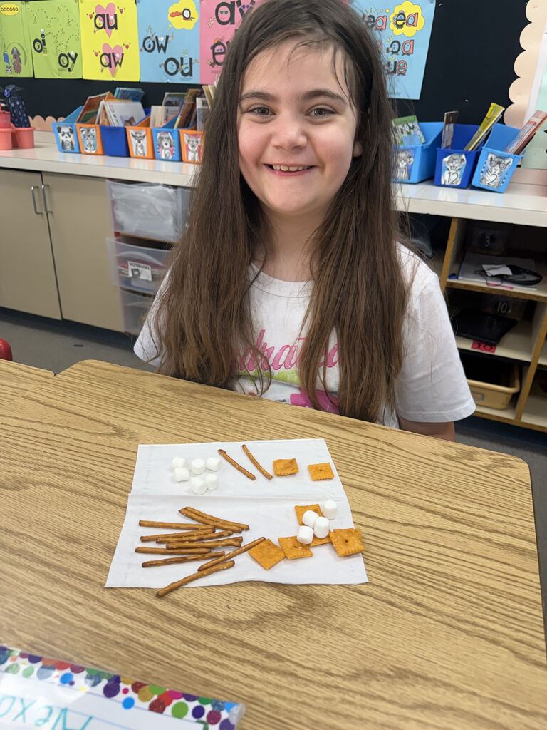student smiling with snacks in front of her