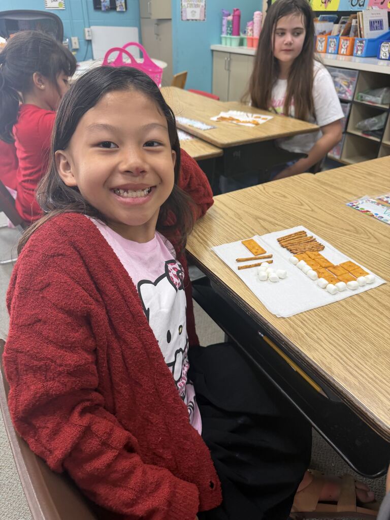 student smiling with snacks in front of her