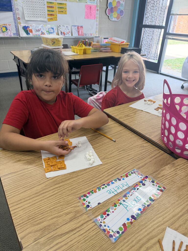 students smiling with snacks in front of them