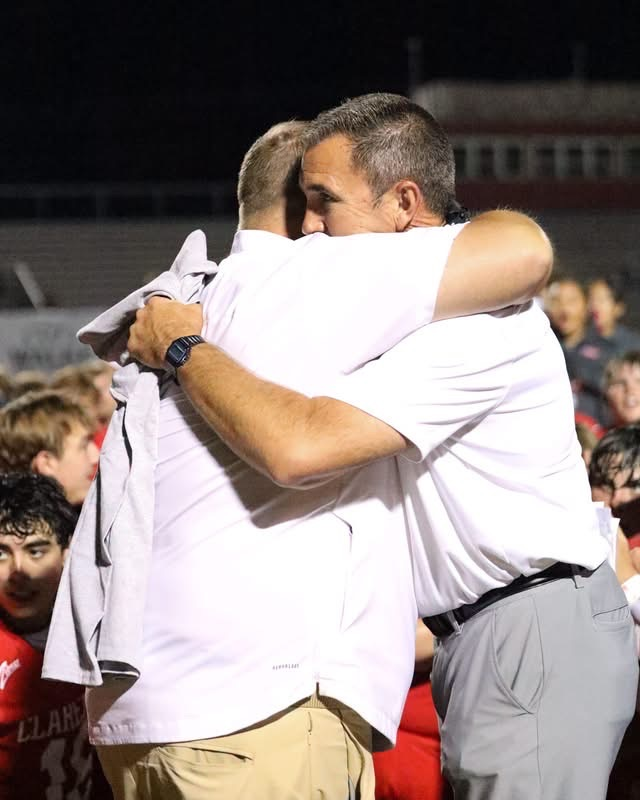 Superintendent Bryan Frazier hugging Coach Hurt