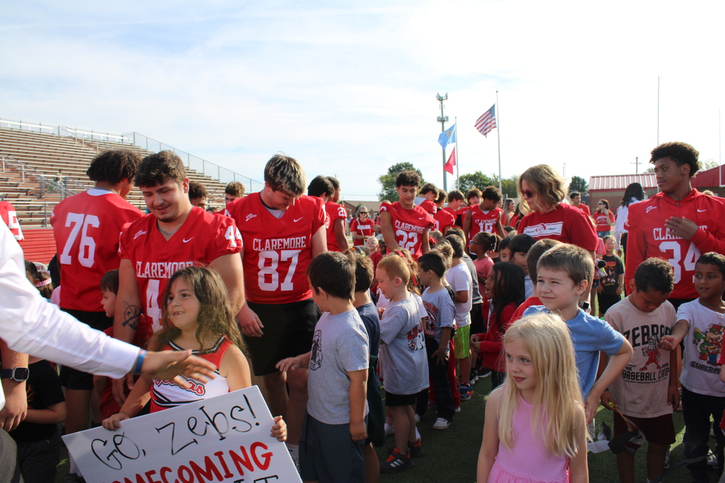 football players slapping students hands