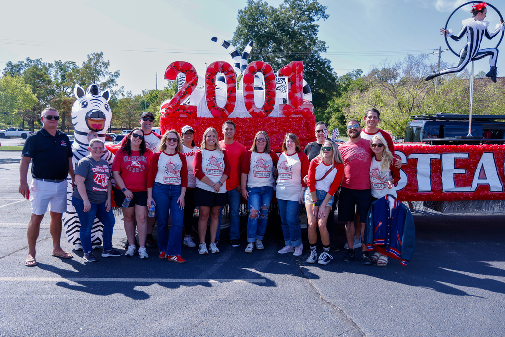 Class of 2001 alumni pose with their Homecoming float.