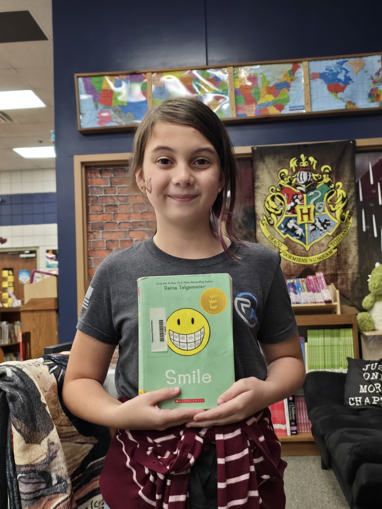student holding a book called Smile