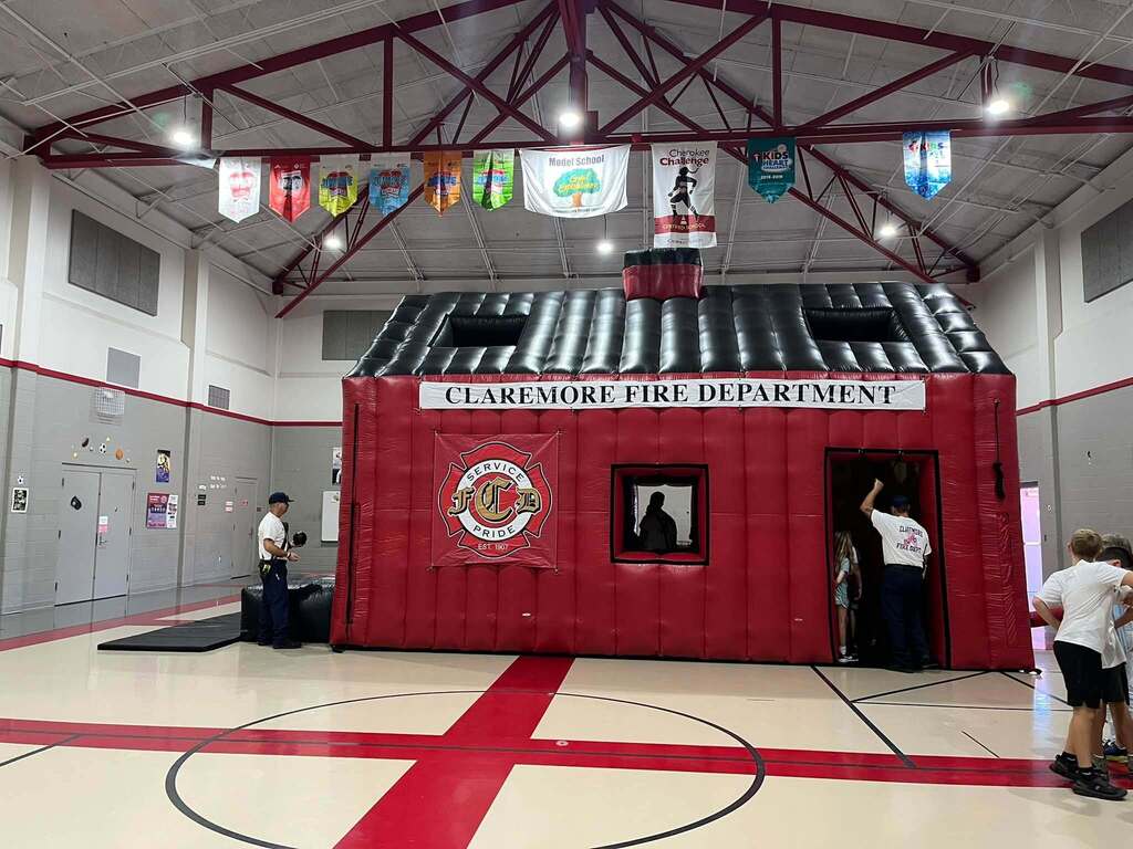 Large inflatable Claremore Fire Department safety house set up inside the gym.