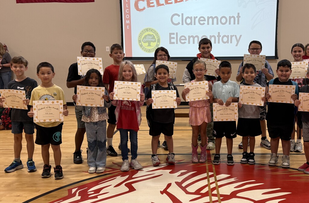 15 students smiling with their student of the month signs