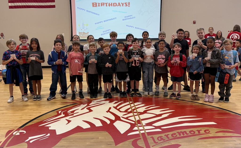 About 25 students smiling with their coupon for their birthday