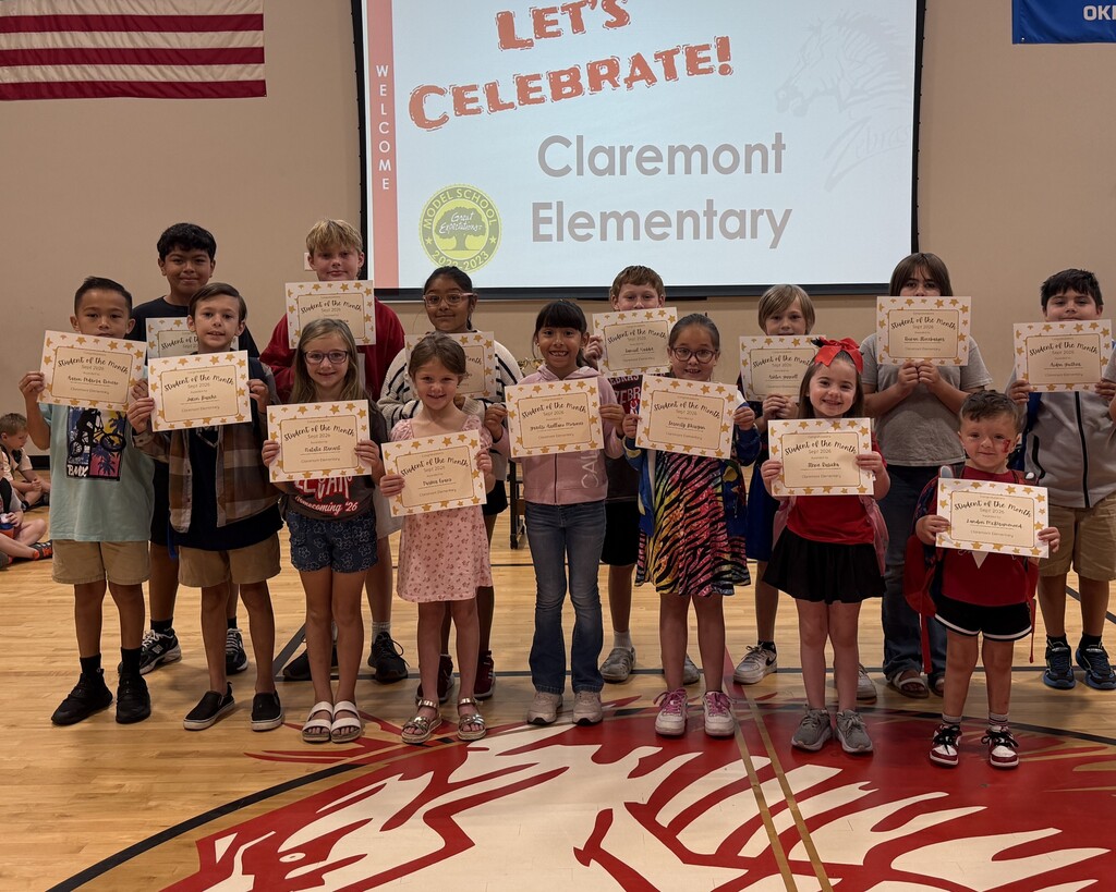 15 students smiling with their student of the month signs