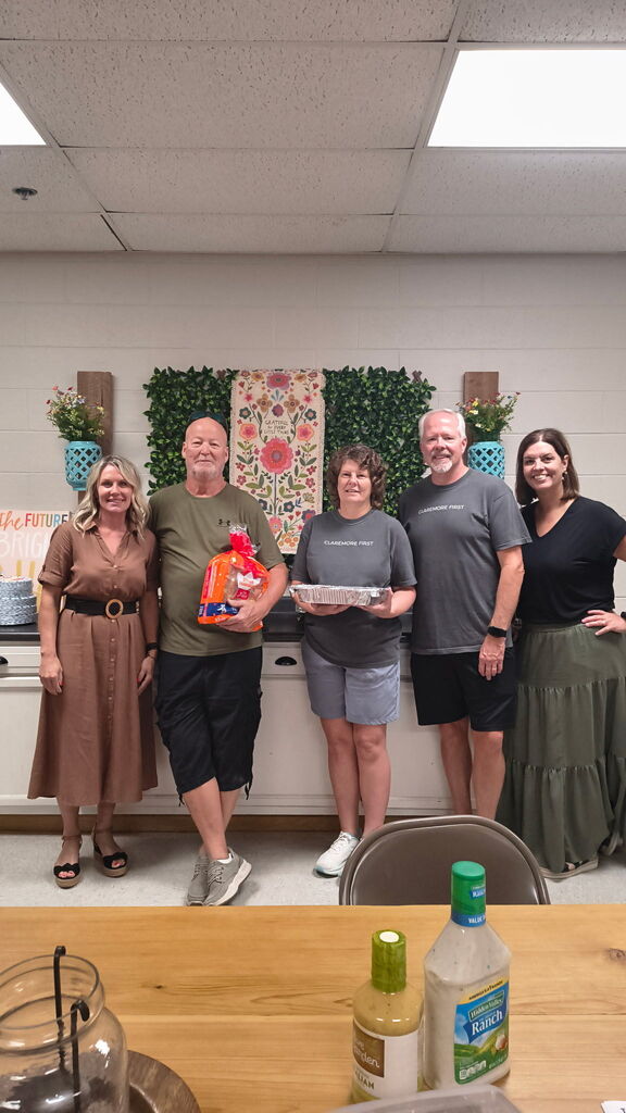 Principals and Claremore First smiling with food items they brought