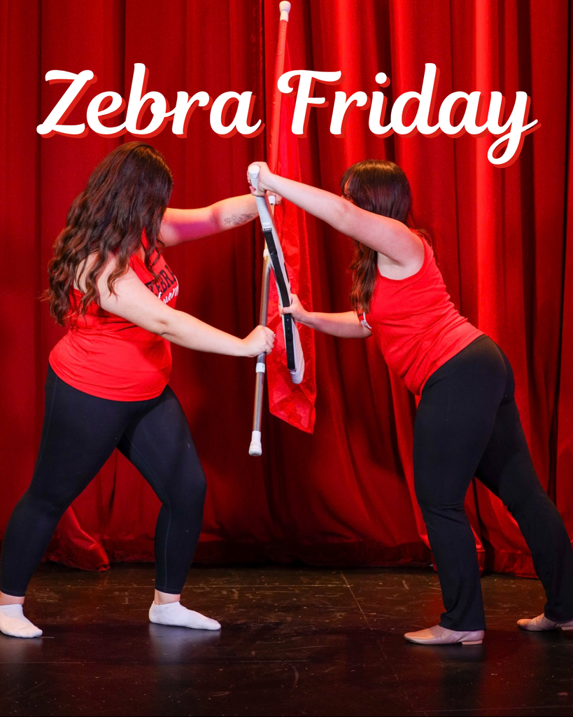 Two color guard members pose with flags in front of red curtains.