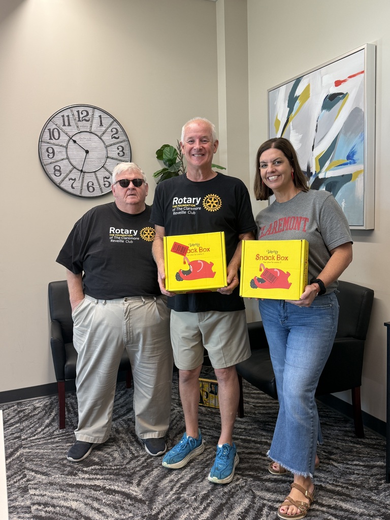 assistant principal and two rotary members smiling with two yellow snack boxes