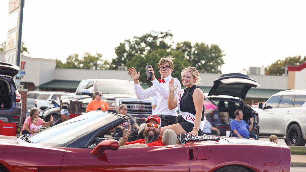 Homecoming Court representatives wave from a convertible during the parade.