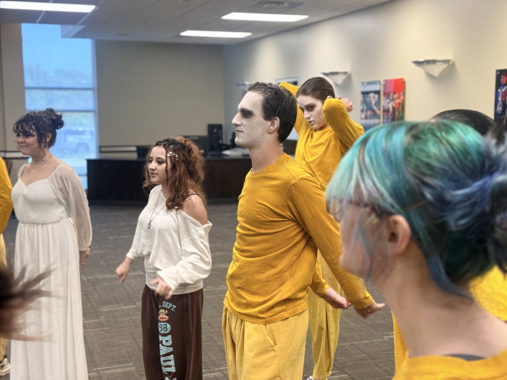 Student actors rehearse a scene together in costume.