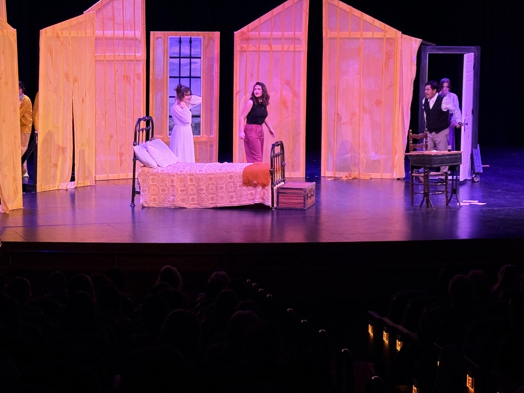 Student actors perform a dramatic scene on stage during The Yellow Wallpaper.