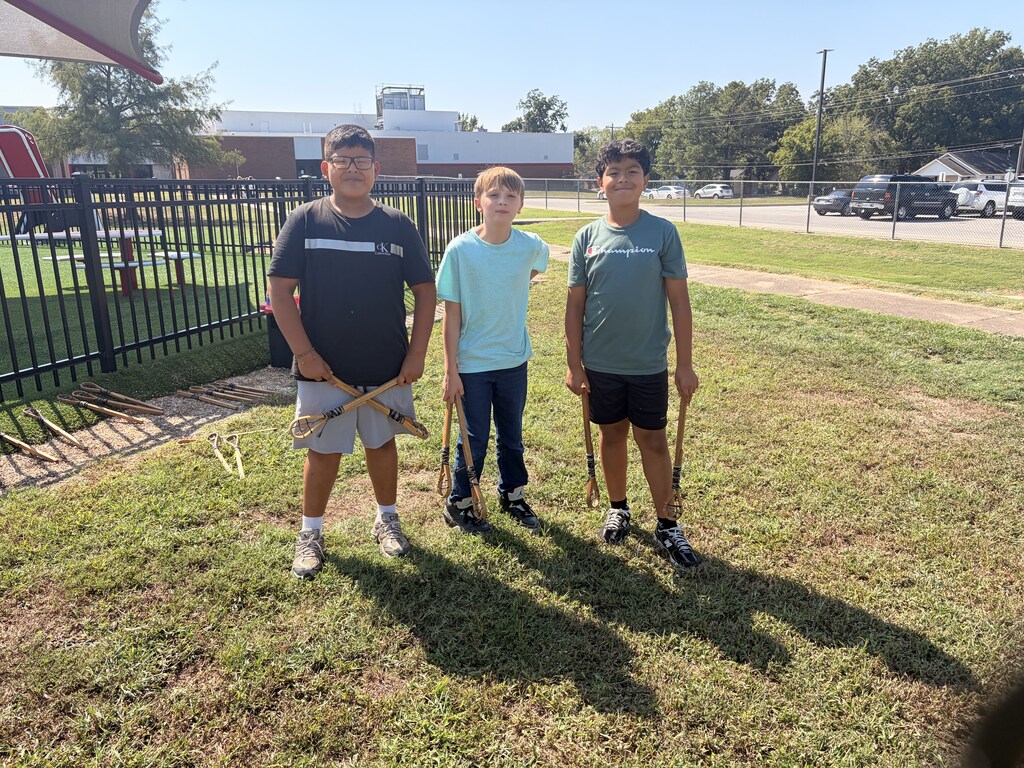 three boys smiling outside