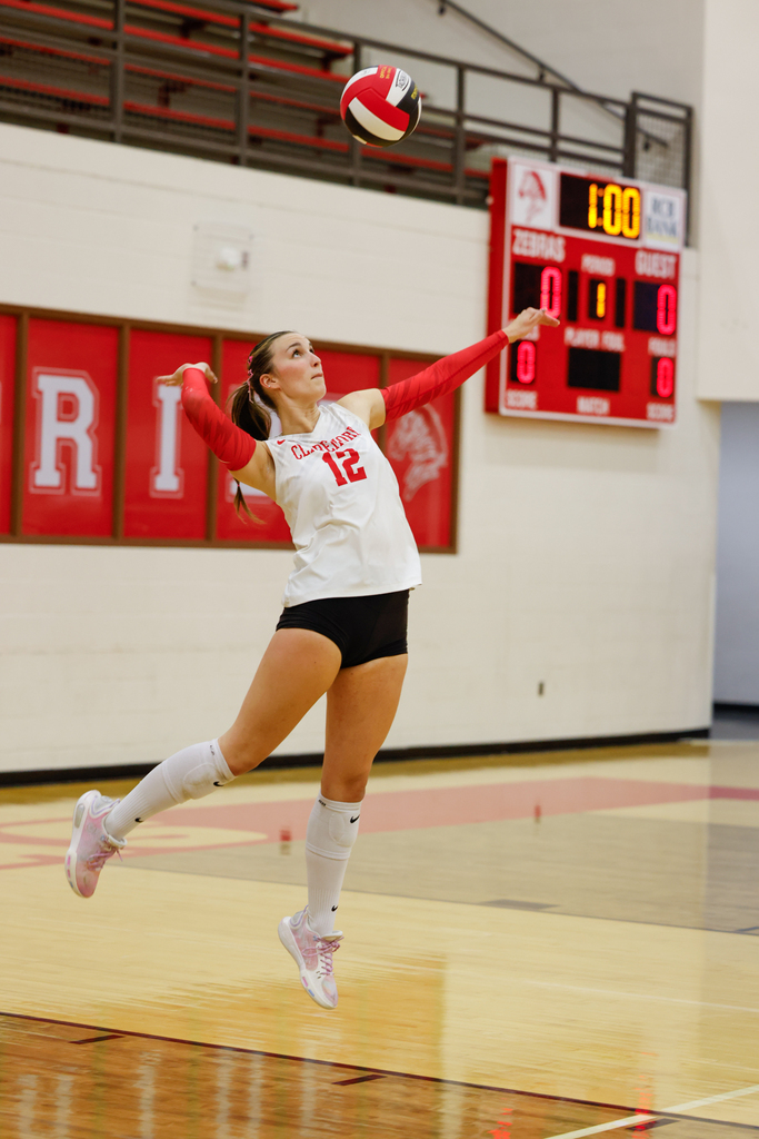 Claremore volleyball player #12 jumps to serve the ball.