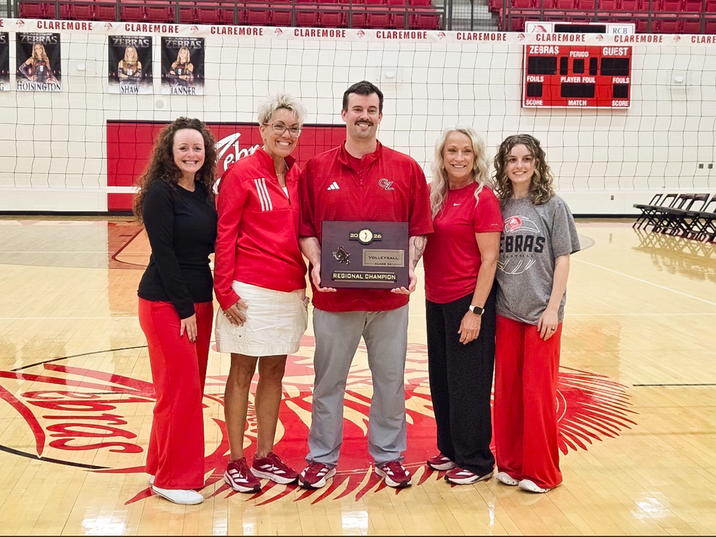 Claremore volleyball coaches and staff pose with the 2026 Regional Championship plaque.