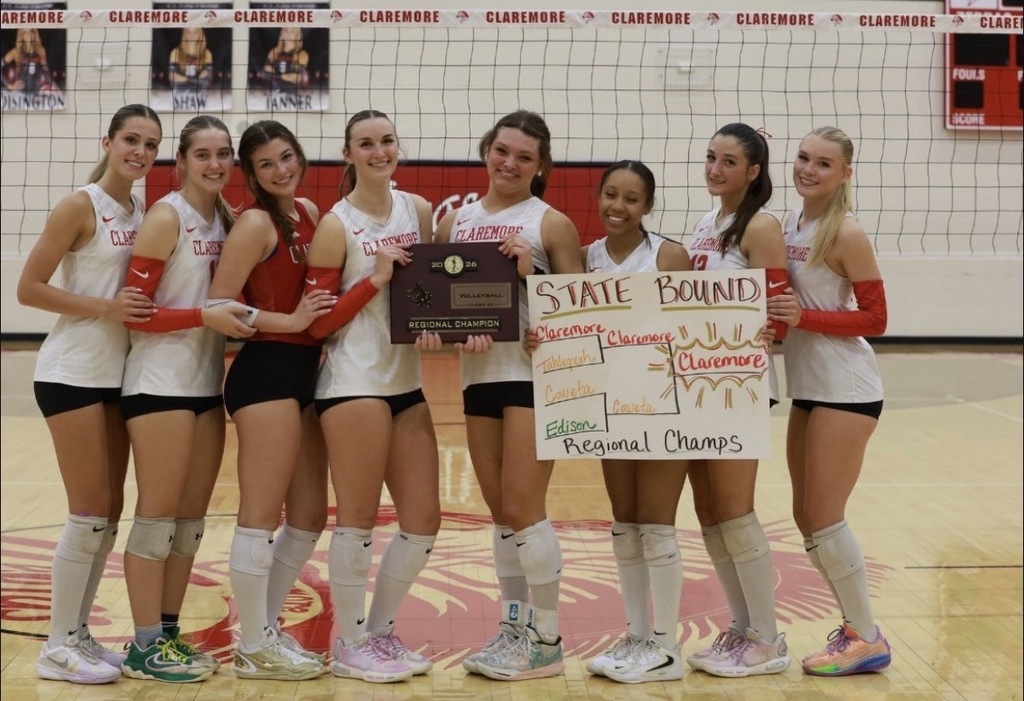 Lady Zebra volleyball players celebrate their Regional Championship with a plaque and State Bound sign.