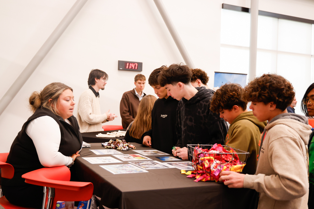 Several students gather around a table to learn about career opportunities.