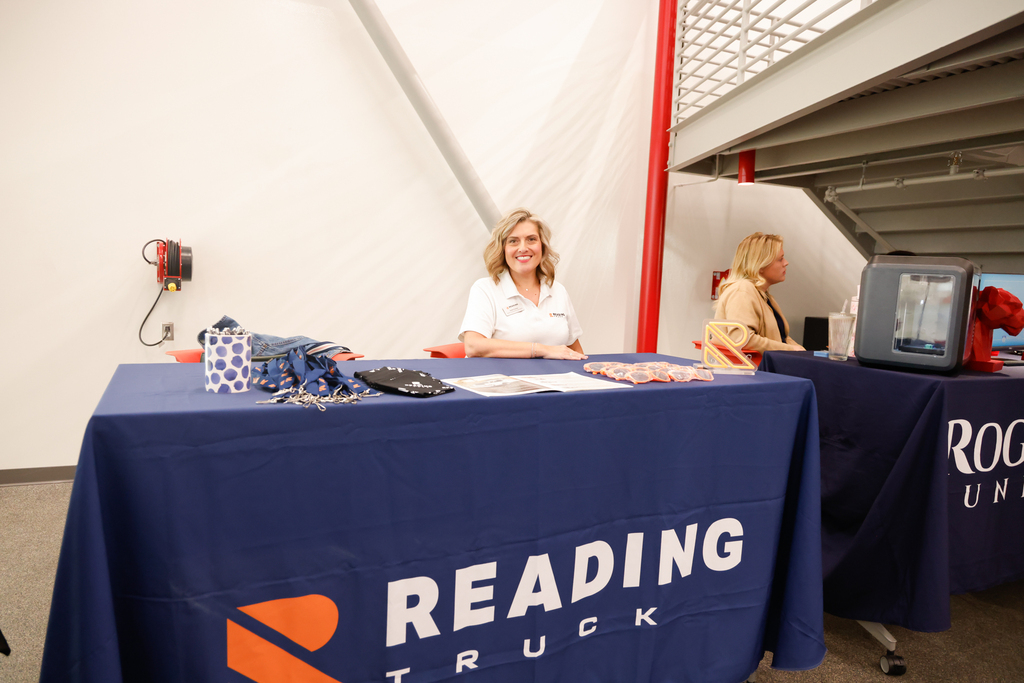 A Reading Truck representative smiles behind a table with brochures and promotional items.