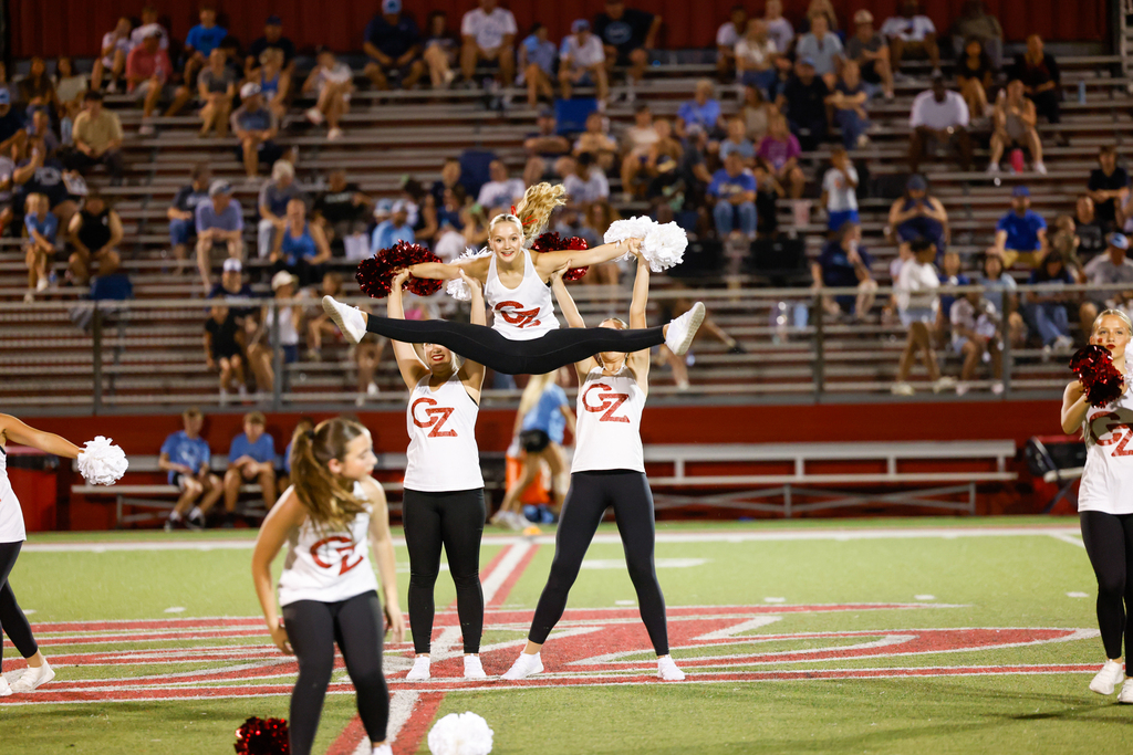 CHS dance team preforming at halftime in their CZ tank tops and black leggings with girl in the air