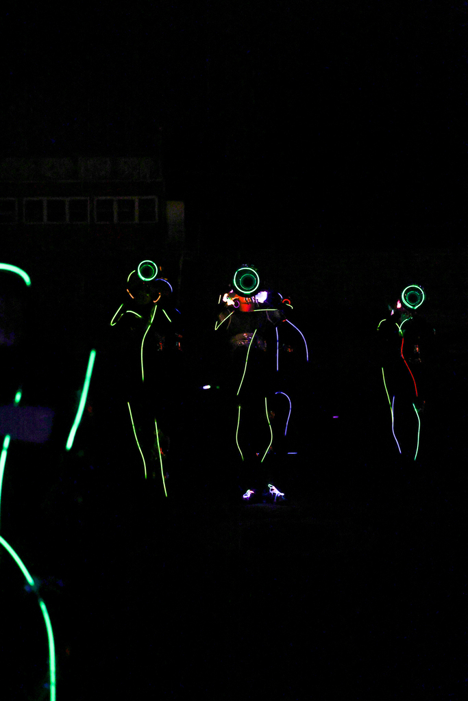 Zebra Band members perform in the dark, outlined in colorful glow sticks with illuminated instruments.