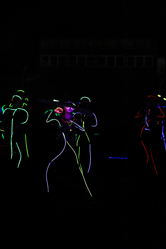 Zebra Band members perform in the dark, outlined in colorful glow sticks with illuminated instruments.