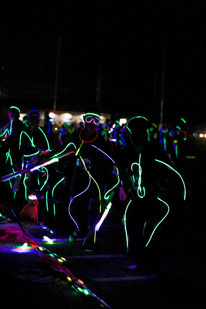 Zebra Band members perform in the dark, outlined in colorful glow sticks with illuminated instruments.