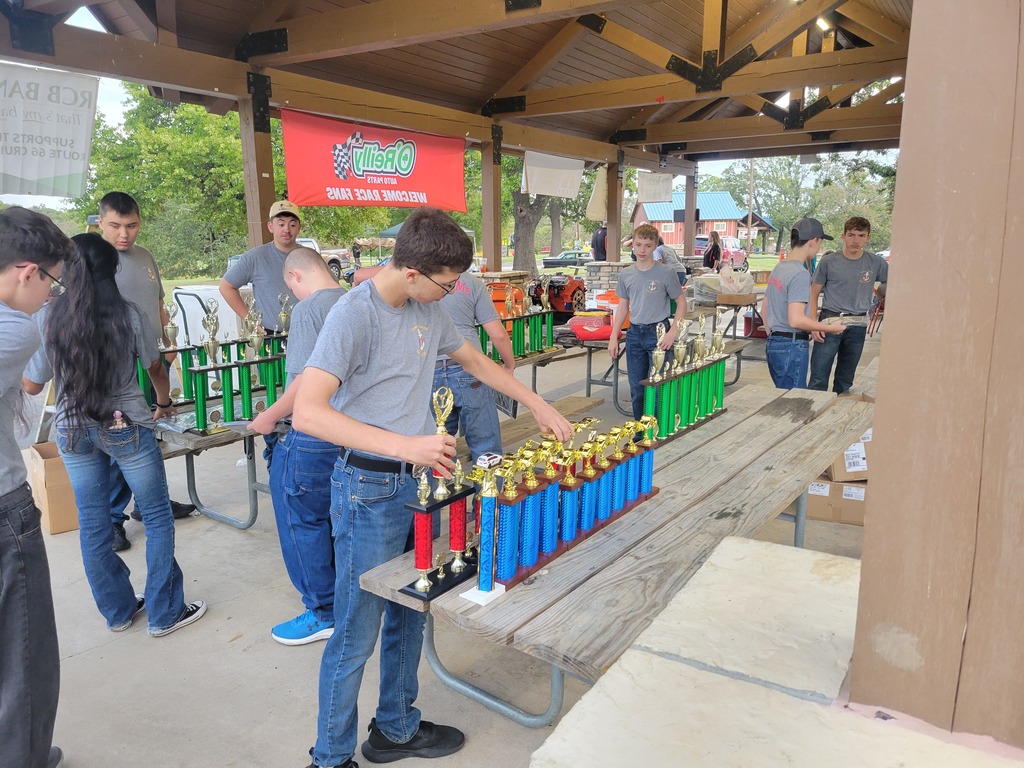 NJROTC cadets organize rows of colorful trophies in preparation for the car show.