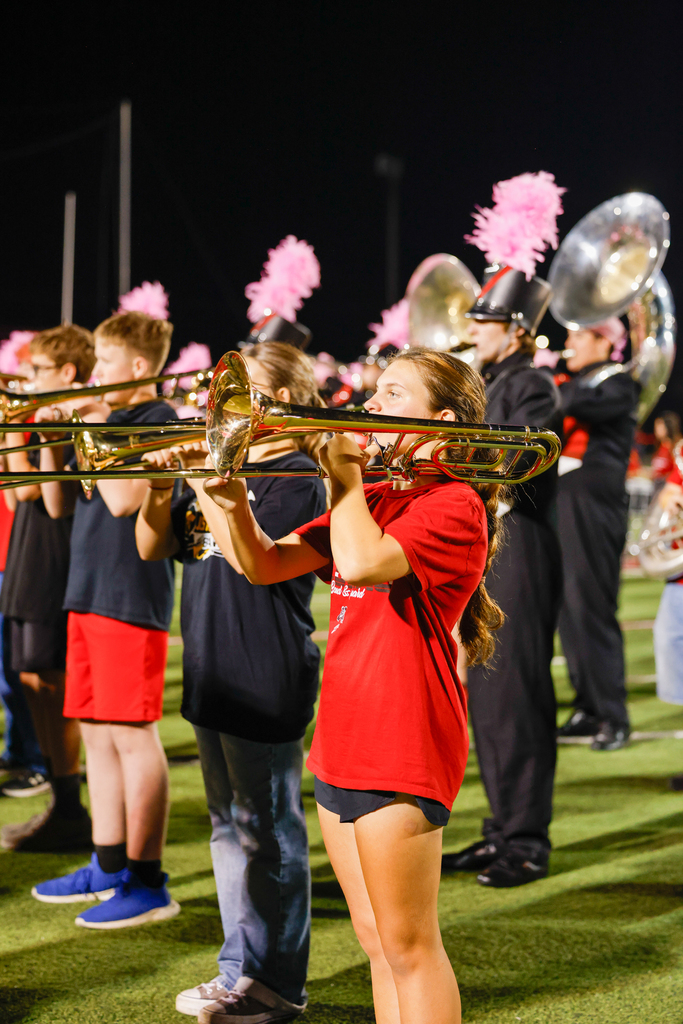 Young trombone players perform alongside the Zebra Band during halftime.