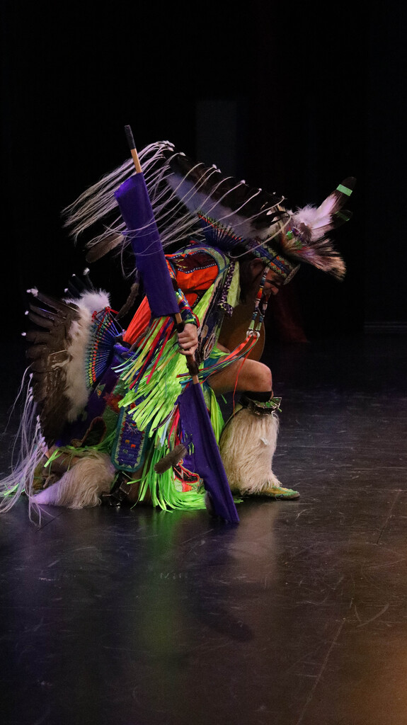 Rising Buffalo dancer kneeling during a performance.