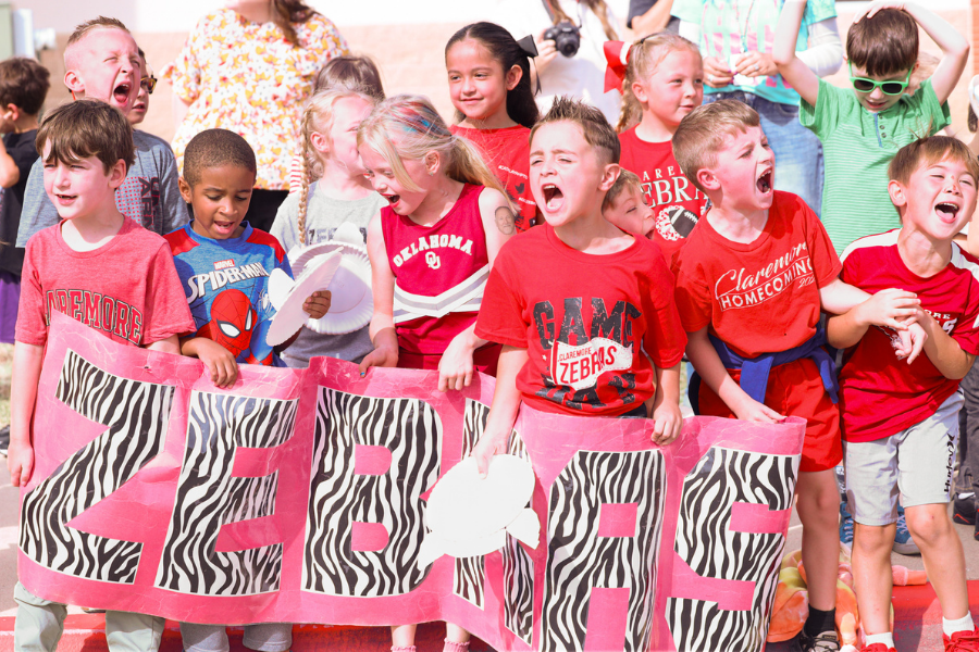 Young Zebras cheer behind a Zebra Pride banner.