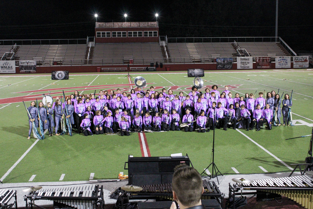 The Zebra Marching Band and Color Guard pose for a group photo on Lantow Field.