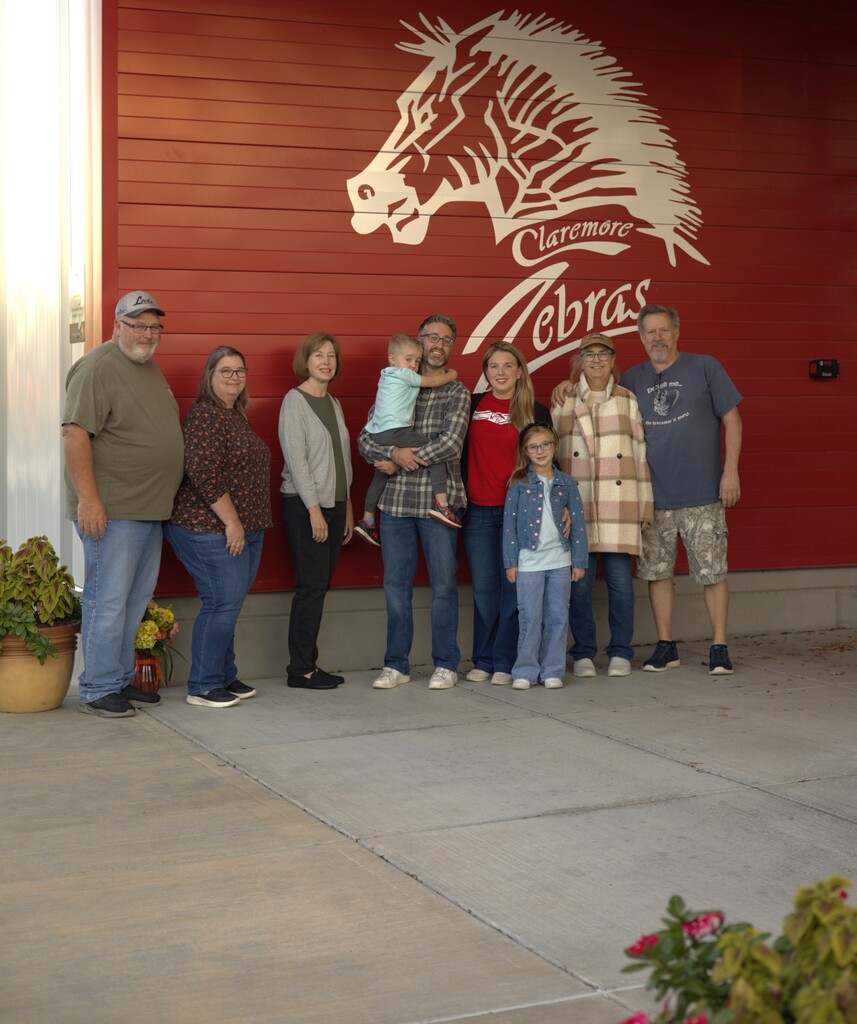 8 family members with Mrs. Stanart smiling in front of a zebra