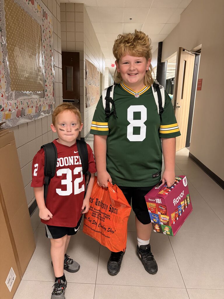 Two students smiling and holding snacks