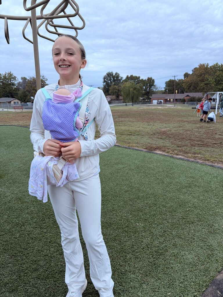 a student smiling dressed as a nurse and mother